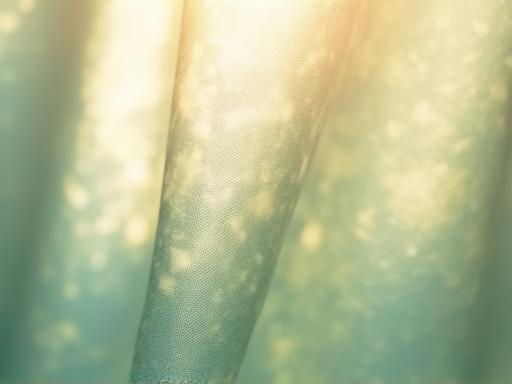 自然染料で染められた環境に優しい布地が光にかざされている様子。